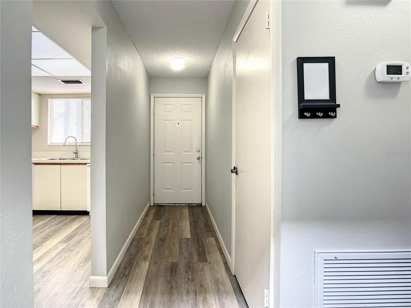 Front door at the end of the entry hall. Kitchen is on the left