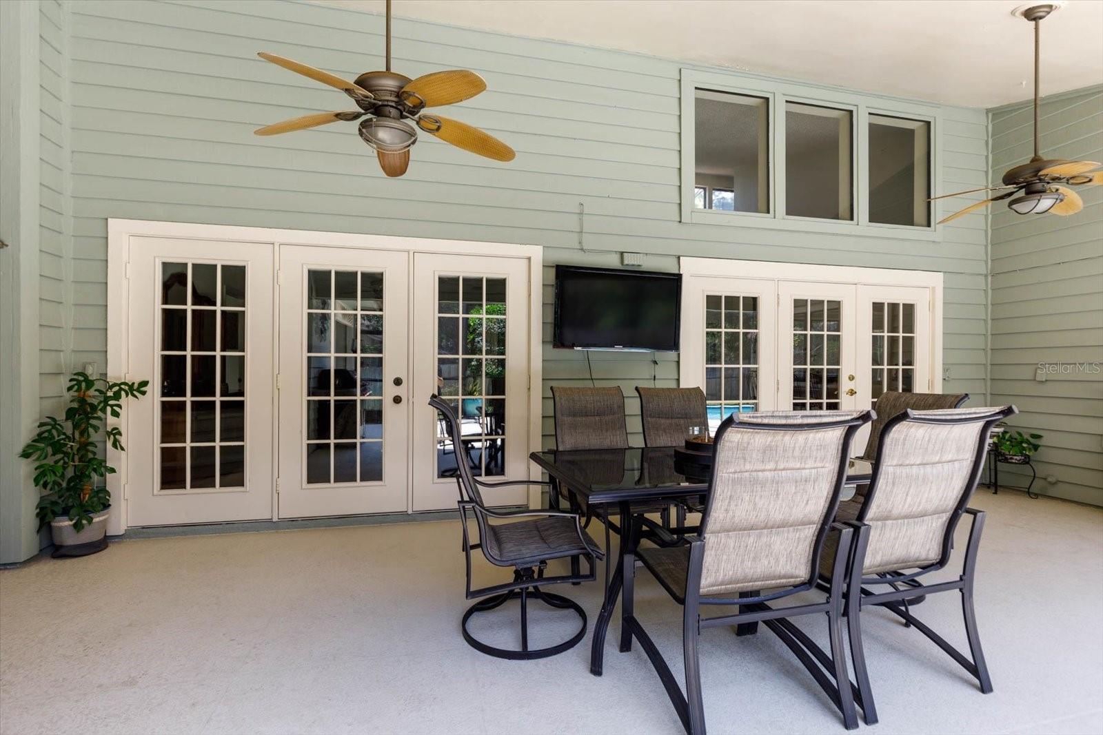 Lanai al fresco dining area with French door entrances to Primary Bedroom and Living room.