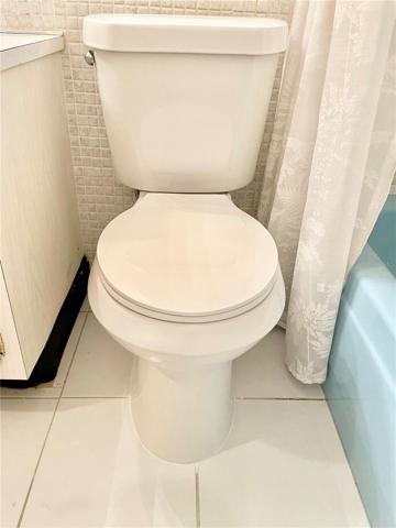 NEW white toilet in Guest Bathroom with tub / shower combo.