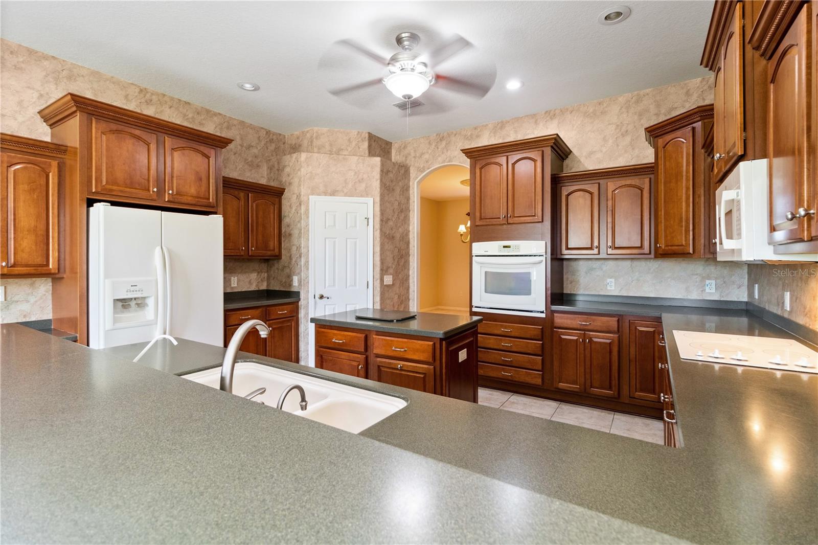 A well laid out kitchen with plenty of counter space - perfect for cooking and baking during the holidays and a closet pantry providing even more storage! The arched doorway leads to the formal Living Room and Dining Rooms
