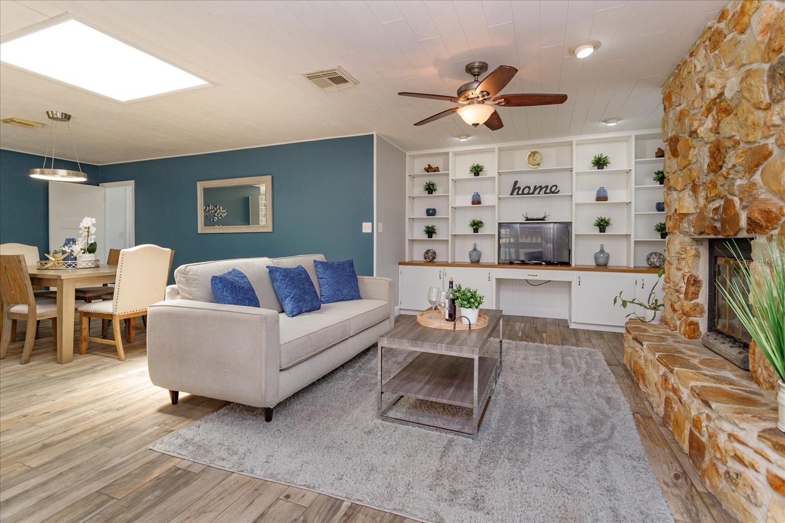 Family room has a stone wood-burning fireplace and many built ins.