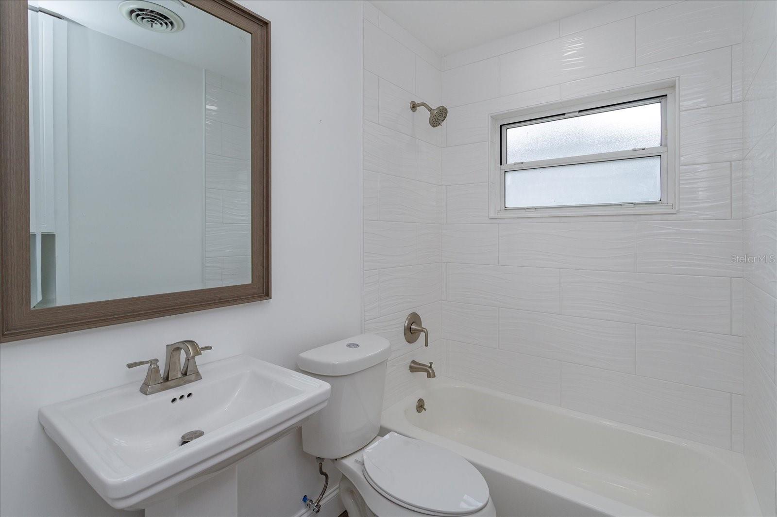 Hall bath has new shower tile, new sink, new toilet and new fixtures.