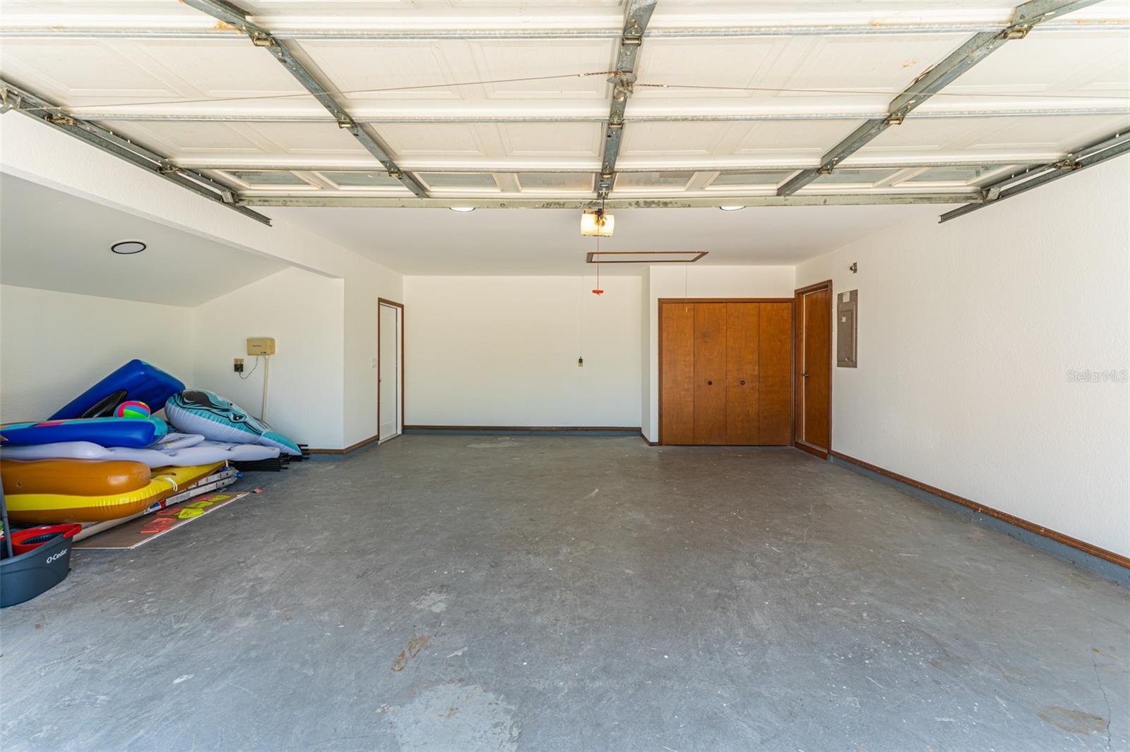 Oversized 2-car garage with storage nook and attic access stairs