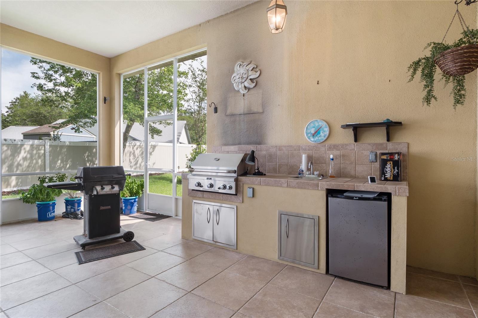 Built in summer kitchen with gas grill, sink and fridge