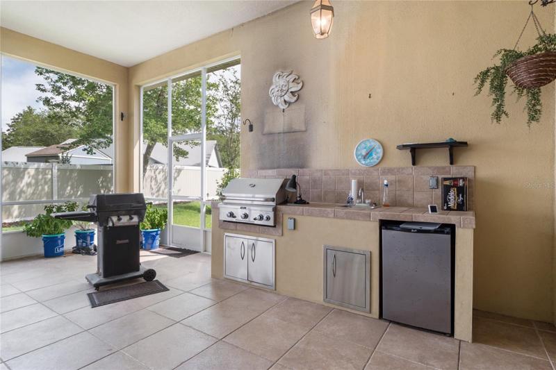 Built in summer kitchen with gas grill, sink and fridge