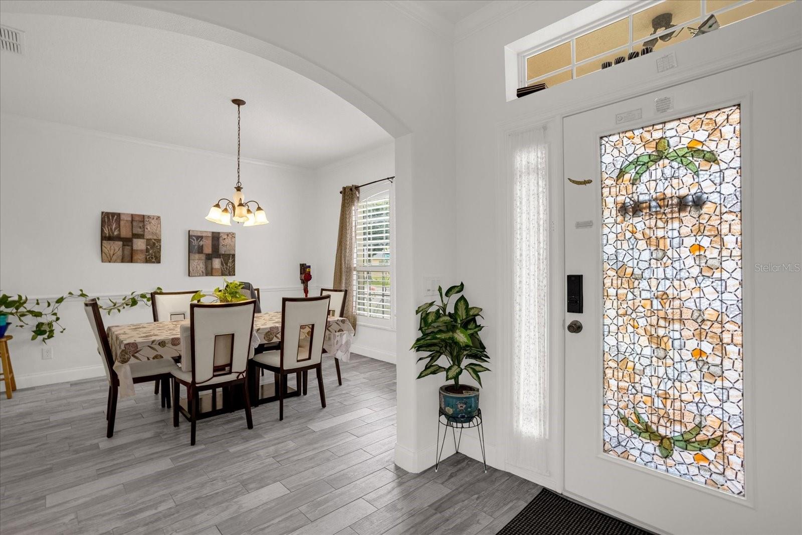 WELCOME HOME! Front entrance Foyer area is between the Formal Living and Dining areas. All Ceramic wood plank tiles welcome you and carry through a majority of the home.
