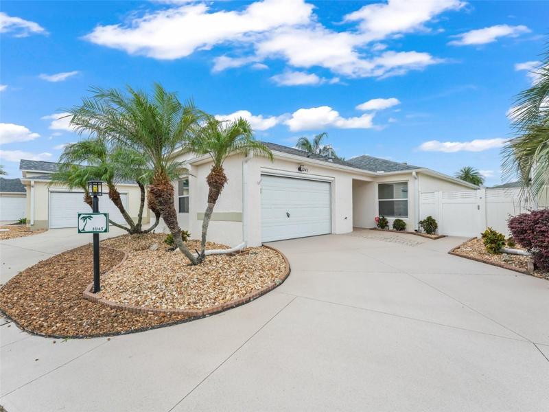 Front View of the Home Showcasing Lovely Robellini Palms and Rock Beds