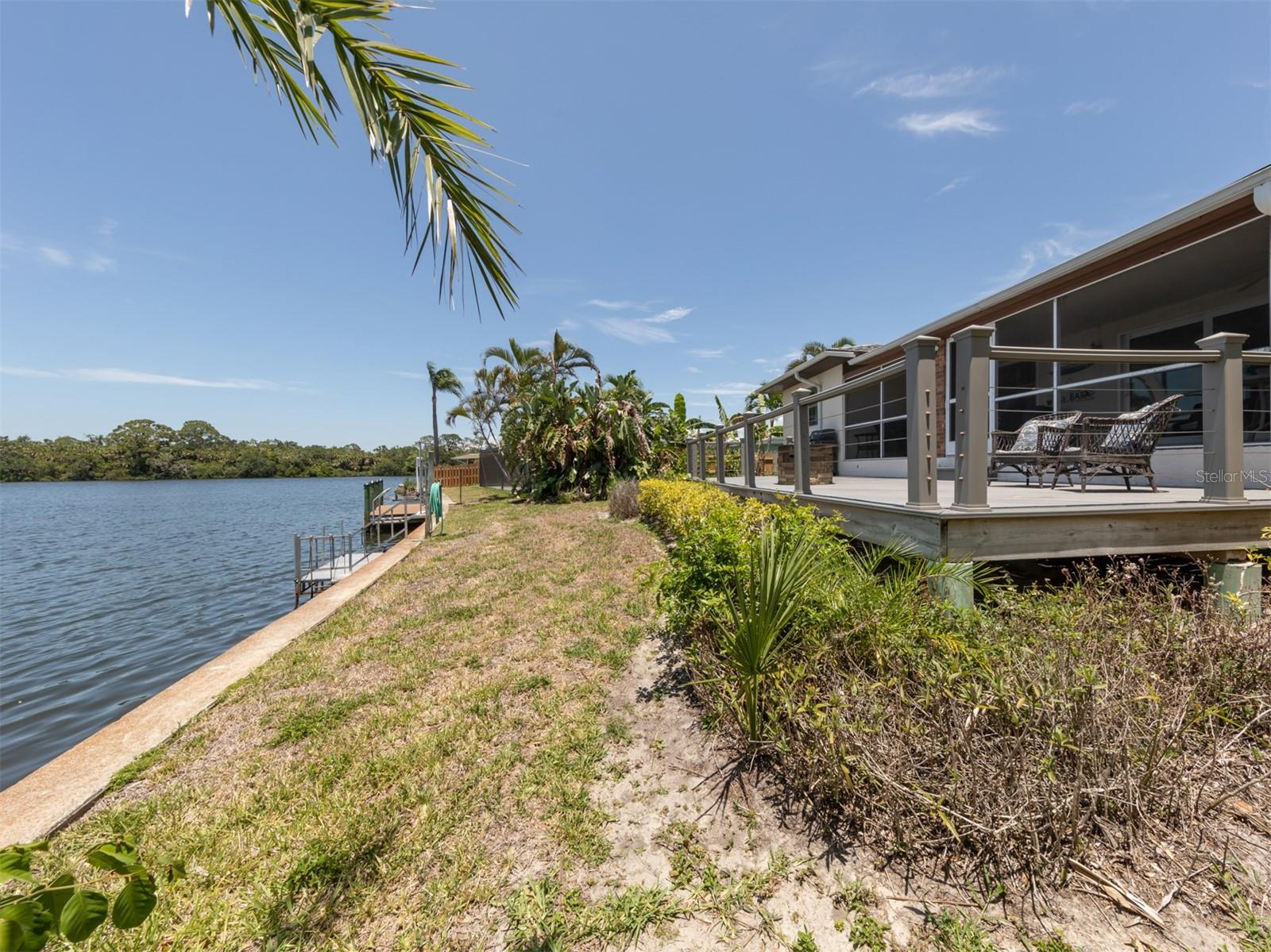 Concrete seawall and small dock with water.