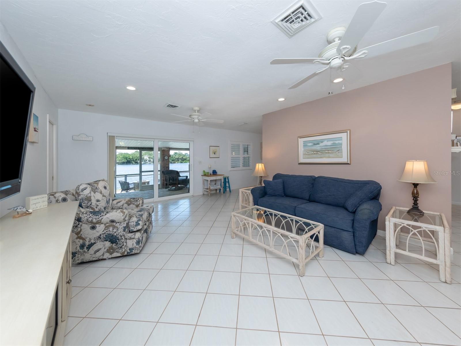 Large living room with bay view through pocket sliding glass door with impact glass.