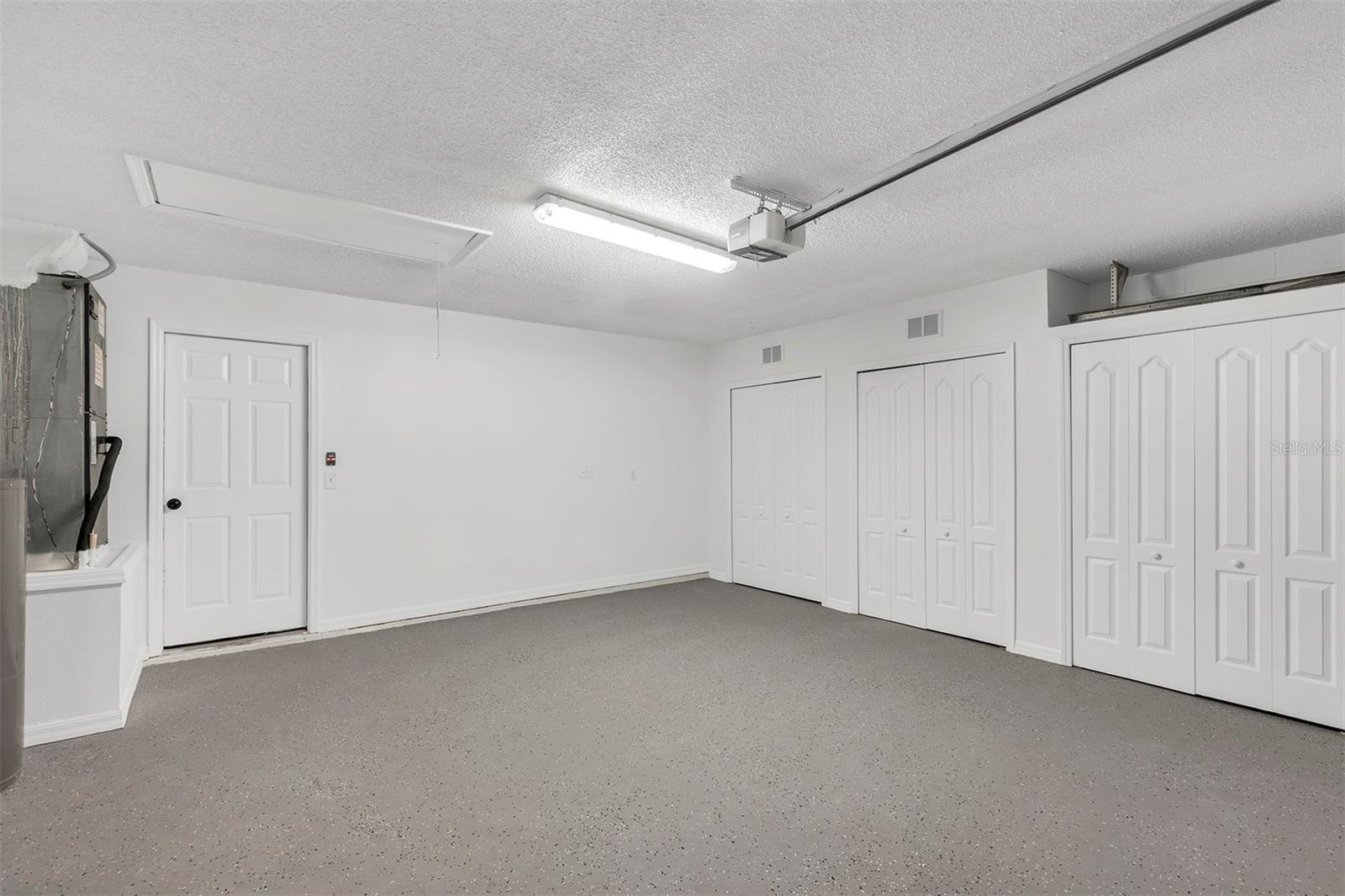 Freshly painted garage. Note the newly done floor and the excellent condition of the garage. Automatic garage door, light fixture and easy access with built-in ladder to the attic. There are ample built-in closets to keep things organized.