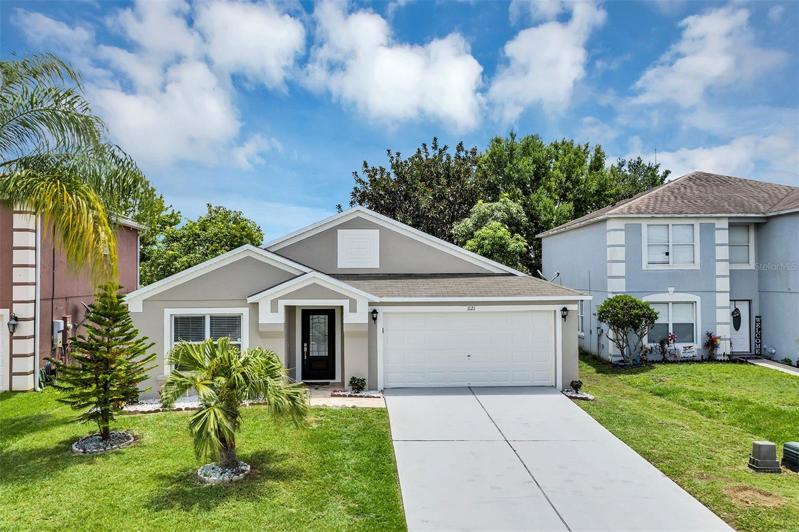 Beautifully landscaped with small trees and plants. Exterior, including driveway, has been freshly painted.