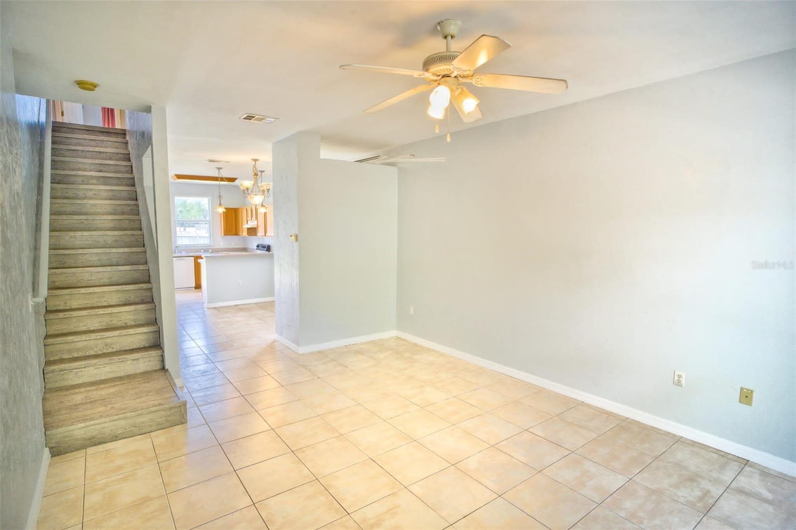 Spacious living room and ceiling fan. Stairs to the 2 master bedrooms!