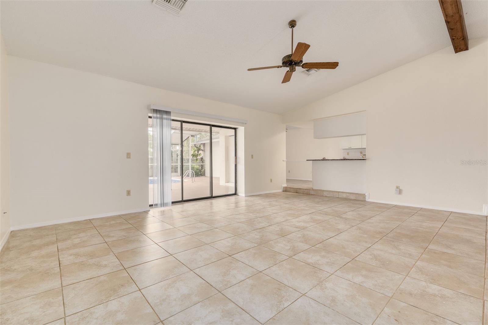 Sunken living room with sliders to lanai, adjacent to kitchen