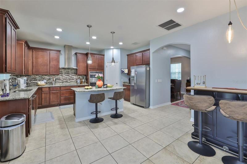 Overlooking the family room, it is spacious, has brand new stainless appliances, recessed panel cabinets and a breakfast bar to grab a quick bite.