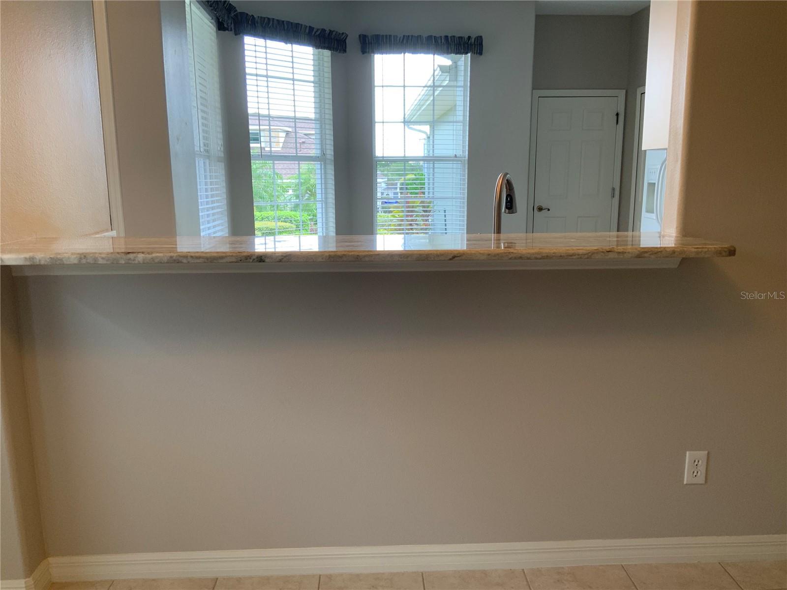 Breakfast Bar, looking into light and bright kitchen.