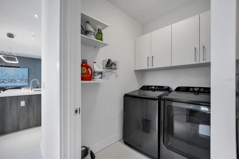 In-unit laundry room with storage and full size washer & dryer.