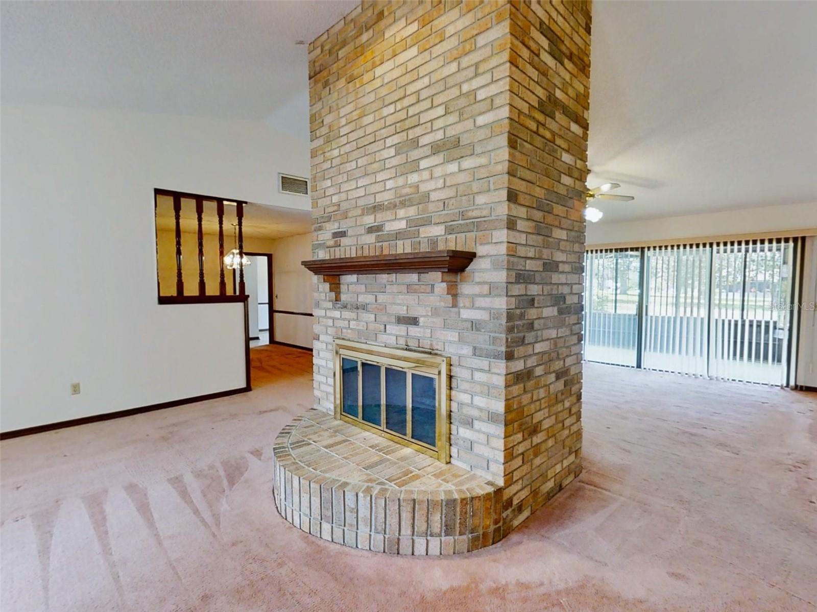 Grand wood-burning fireplace between living &amp; family rooms