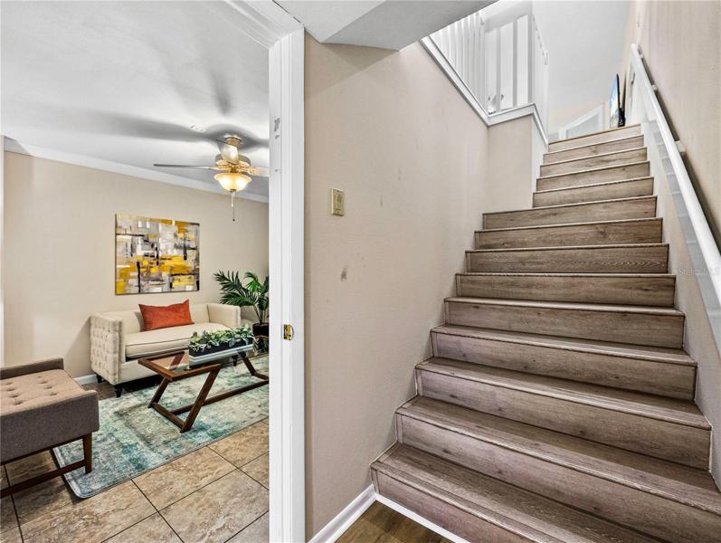 This is looking from the ground floor foyer up the stairs to the second floor! To the left is a downstairs multiple purpose room. It is staged with a sofa-bed and could easily be used for a guest bedroom, though it does not have an exterior window and therefore does not qualify to be called a bedroom.