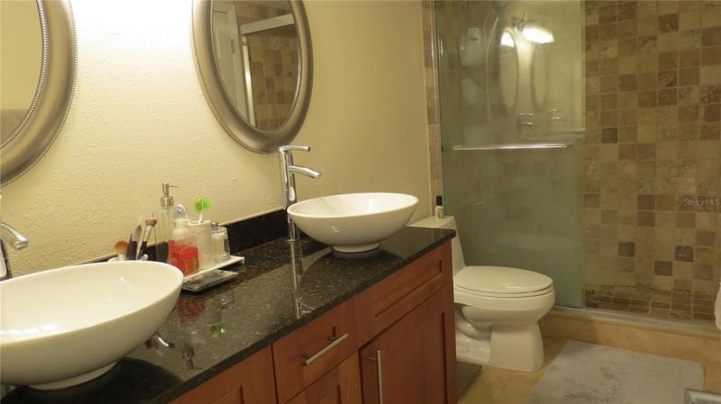 full bath , dual sinks and tiled step in shower