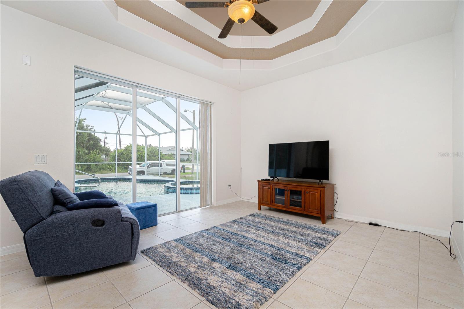 Family room has a double tray ceiling and ceiling fan