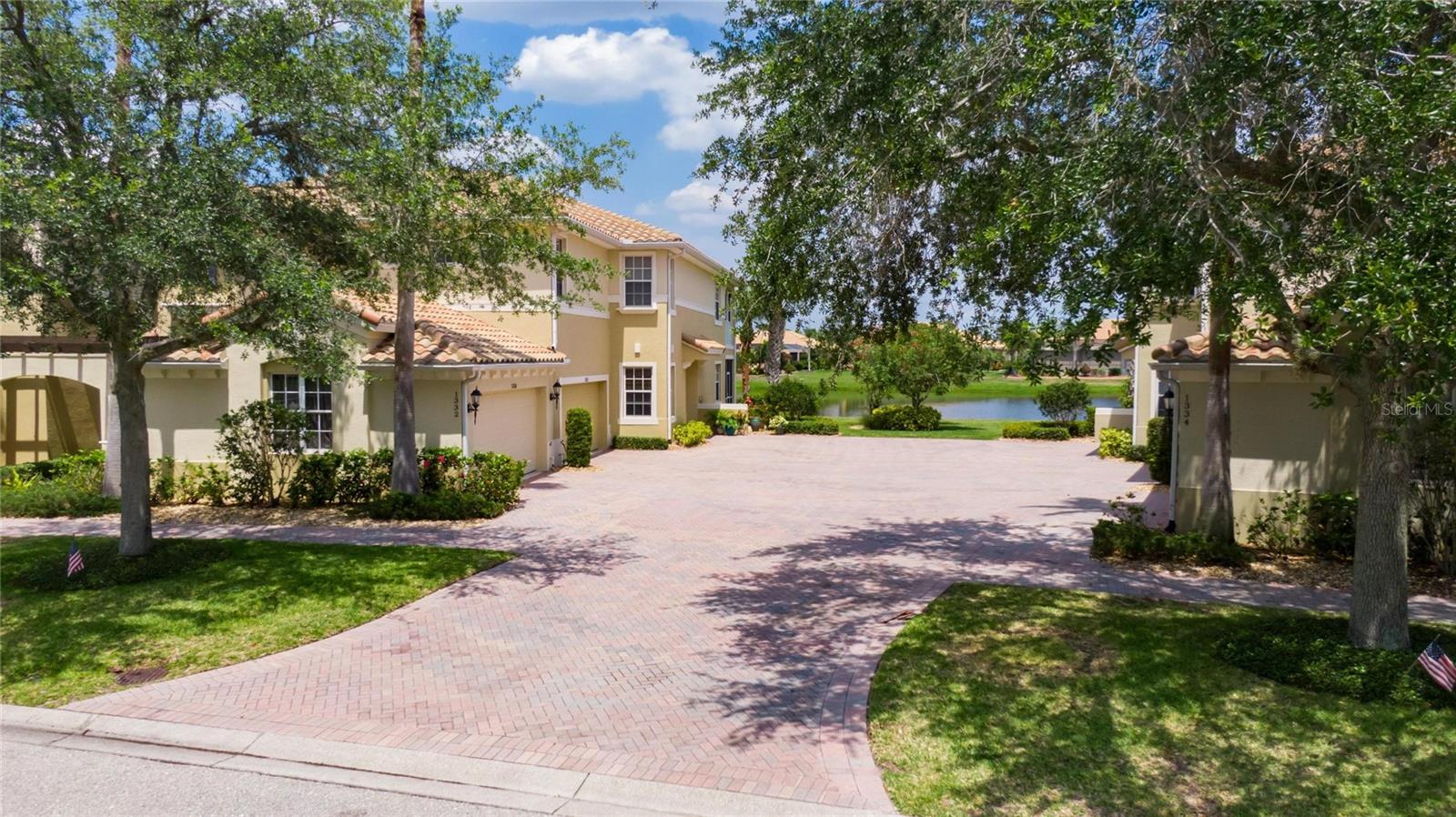 Beautiful Mediterranean style LUXURY first floor condo, a sense of peace and serenity immediately draws you in with open, manicured landscaping.  Extra wide paved driveway for a luxurious feel and lots of room for parking.