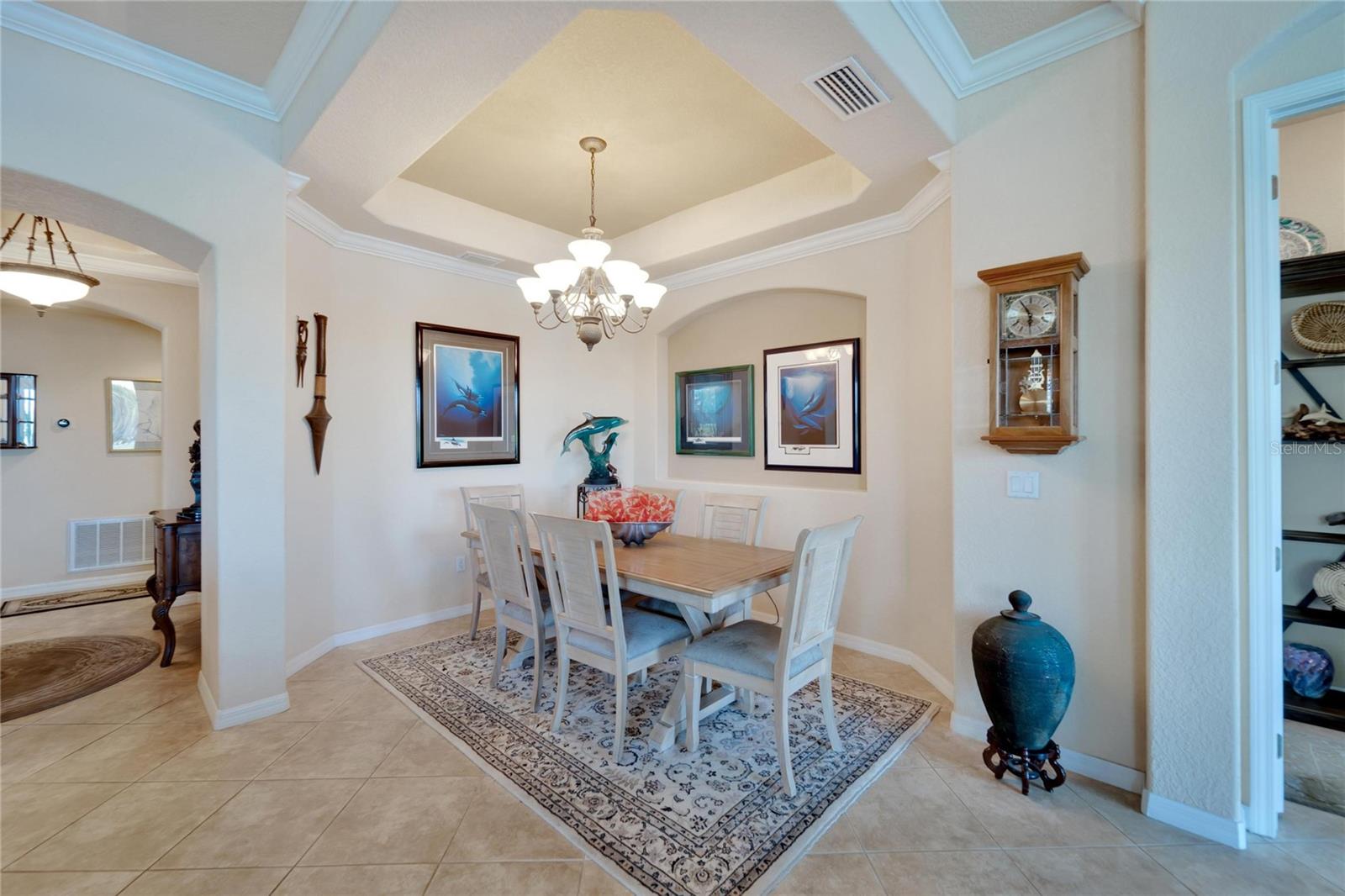The dining area is perfect for entertaining family and friends. Note the high ceiling, trey insert and architectural niche.