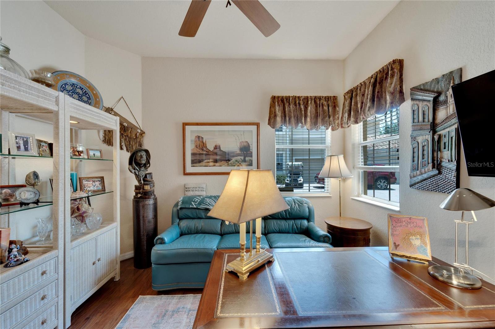 Bedroom #3 and/or office with ceiling fan, ample closet space, and wood floors.