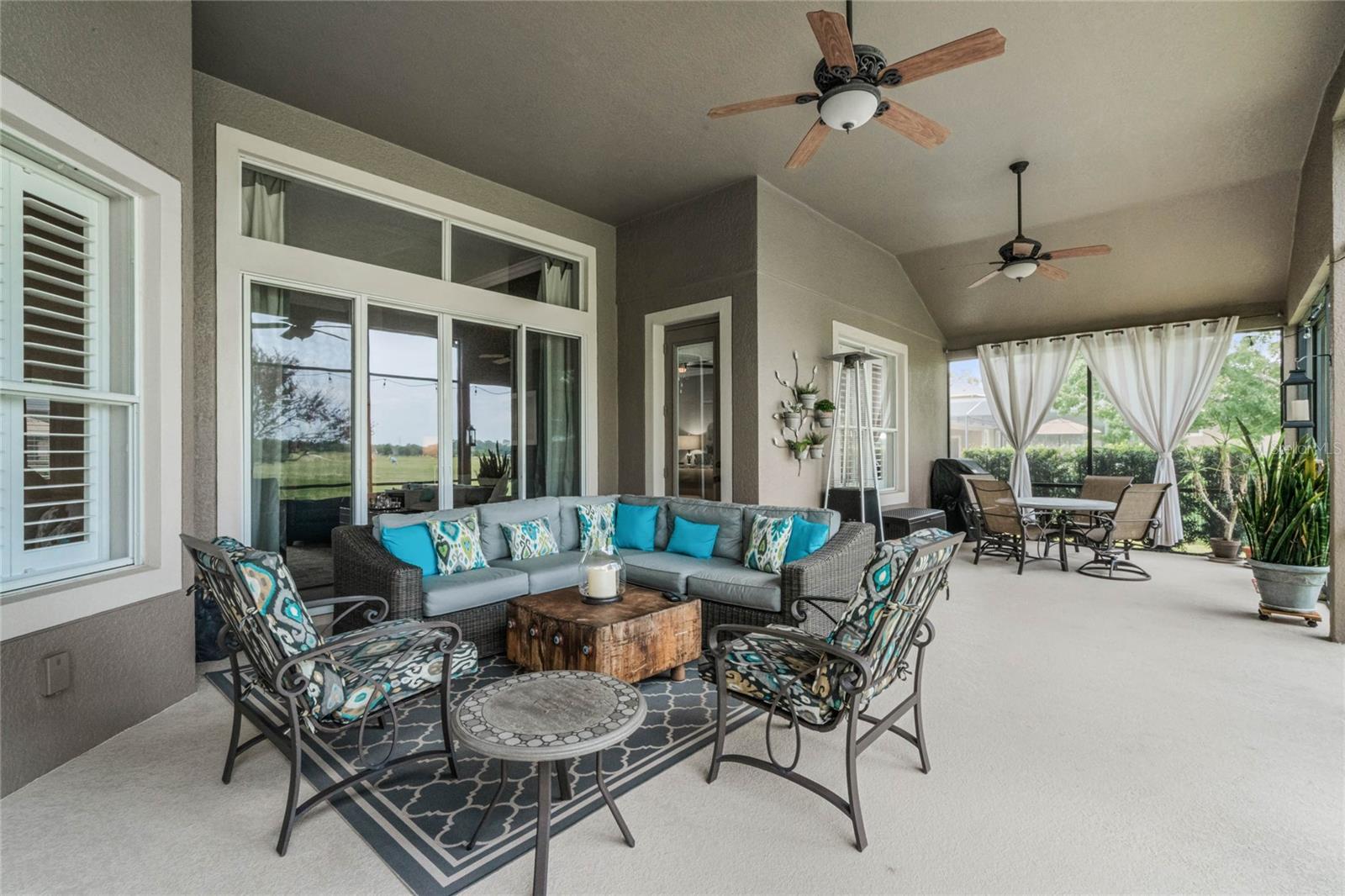TINTED SLIDER DOORS AT BOTH FORMAL LIVING AND FAMILY ROOMS OPEN TO COVERED LANAI