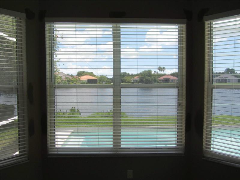 primary bedroom view overlooking pool deck and lake