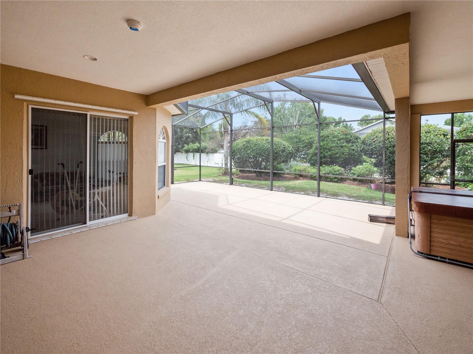 Gorgeous covered and screened back porch, with above-ground hot tub, included.
