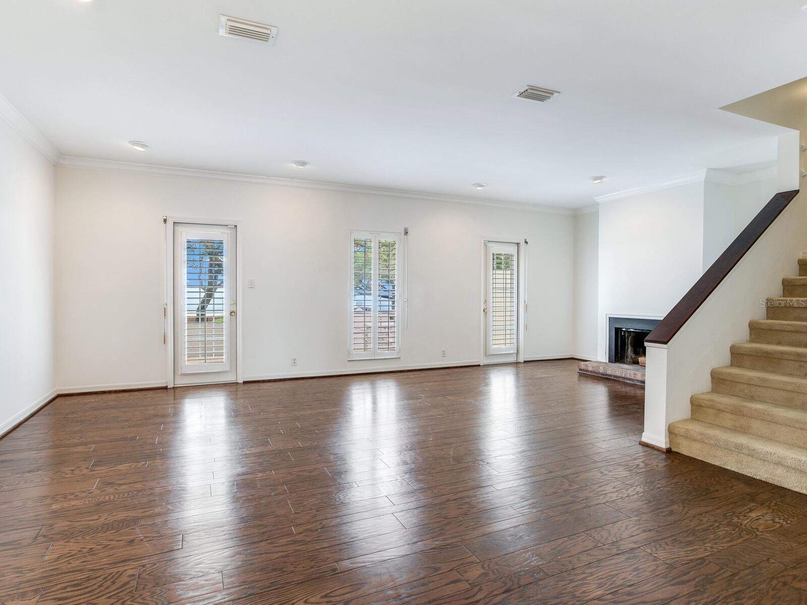 View from kitchen to Great Room with 2 single French doors and wood burning fireplace.