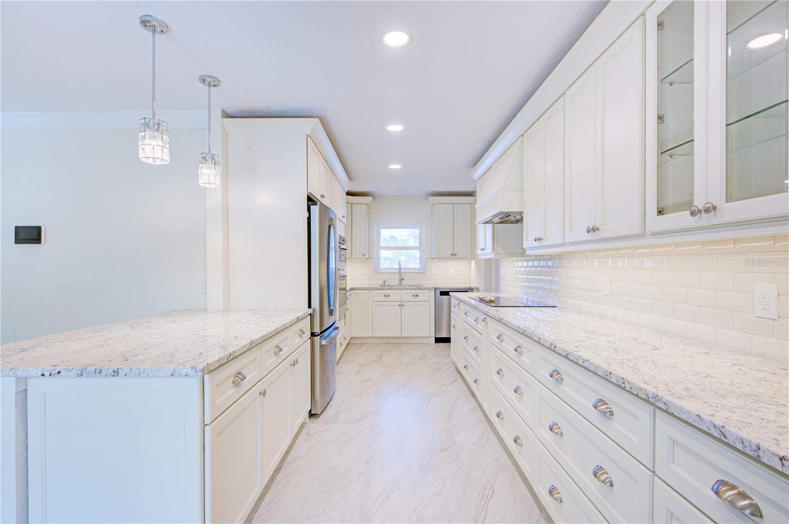 Island featured with granite countertops & porcelain floors throughout kitchn