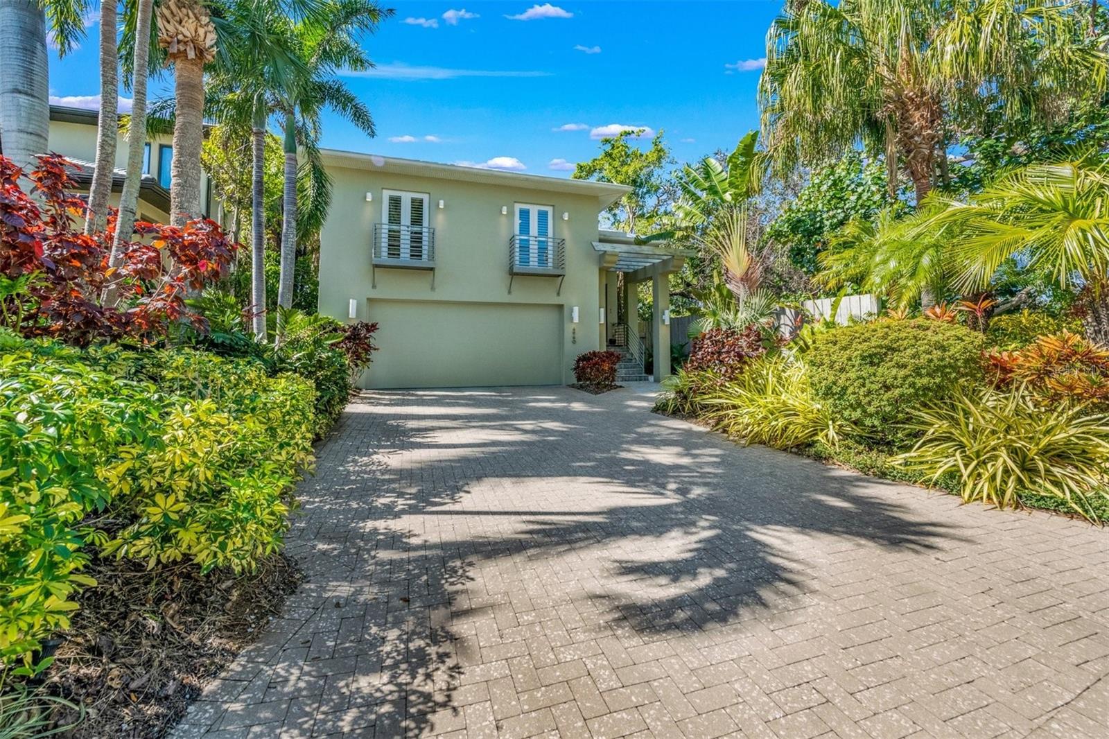 Lush tropical setting with paver brick driveway.