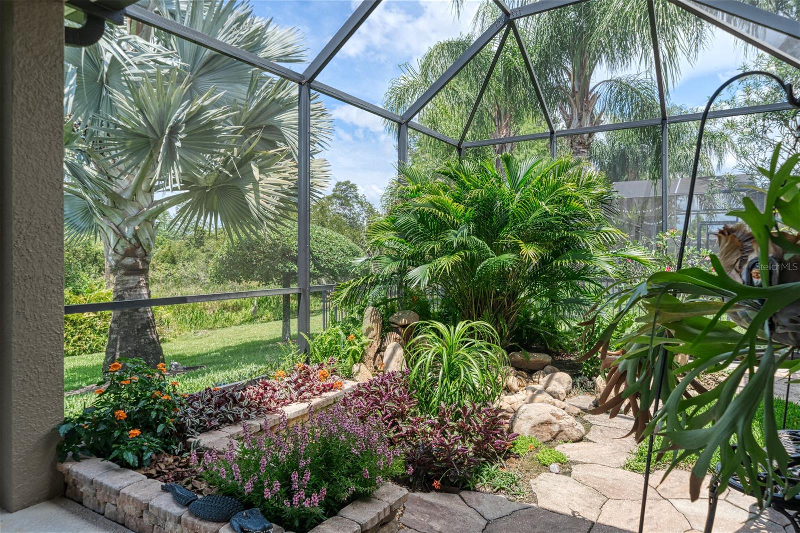 Screened atrium with rock garden and tropical planter beds