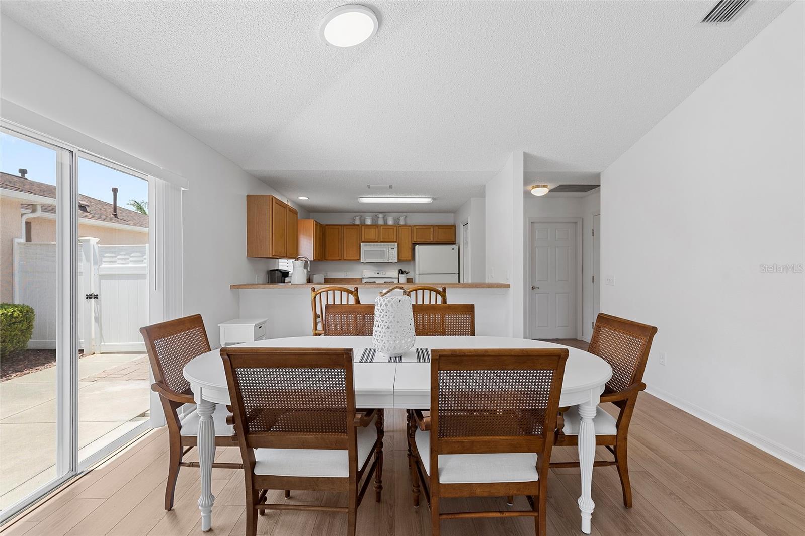 DINING AREA WITH PLENTY OF NATURAL LIGHT COMING IN FROM SOLAR TUBES AND THE SLIDERS THAT LEAD TO THE PATIO