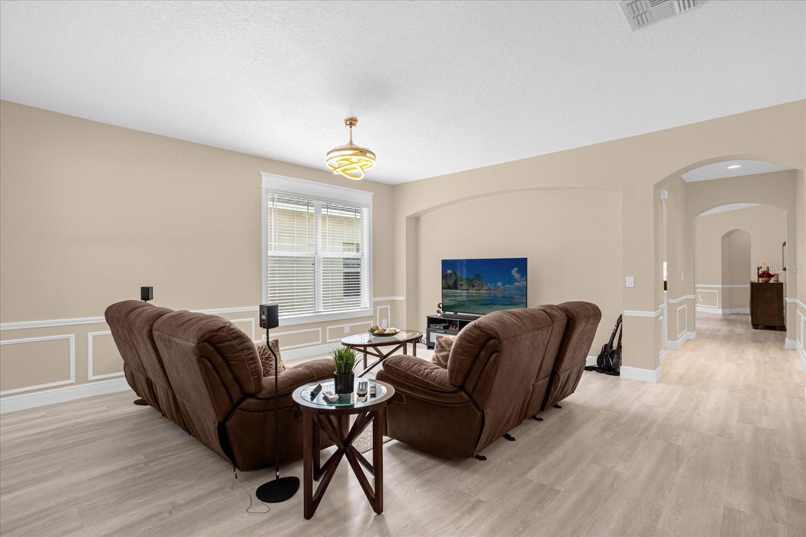 Spacious Formal Living Room featuring wainscot paneling