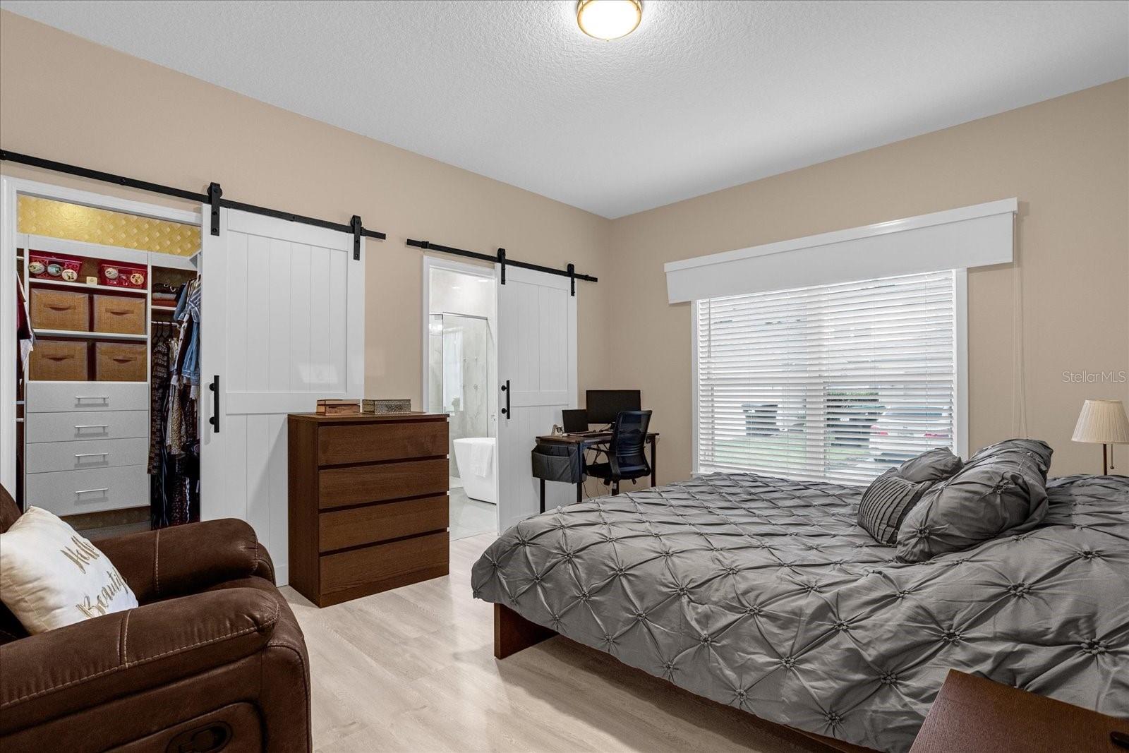The master bedroom features custom closets, new blinds, new barn doors