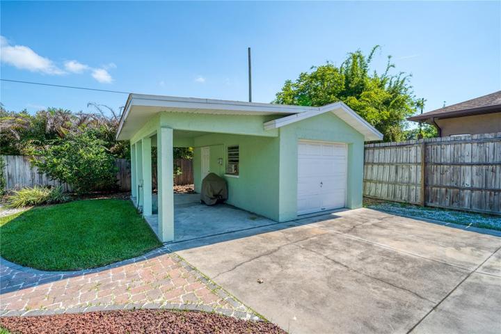 Detached 1 car garage with covered sitting area.