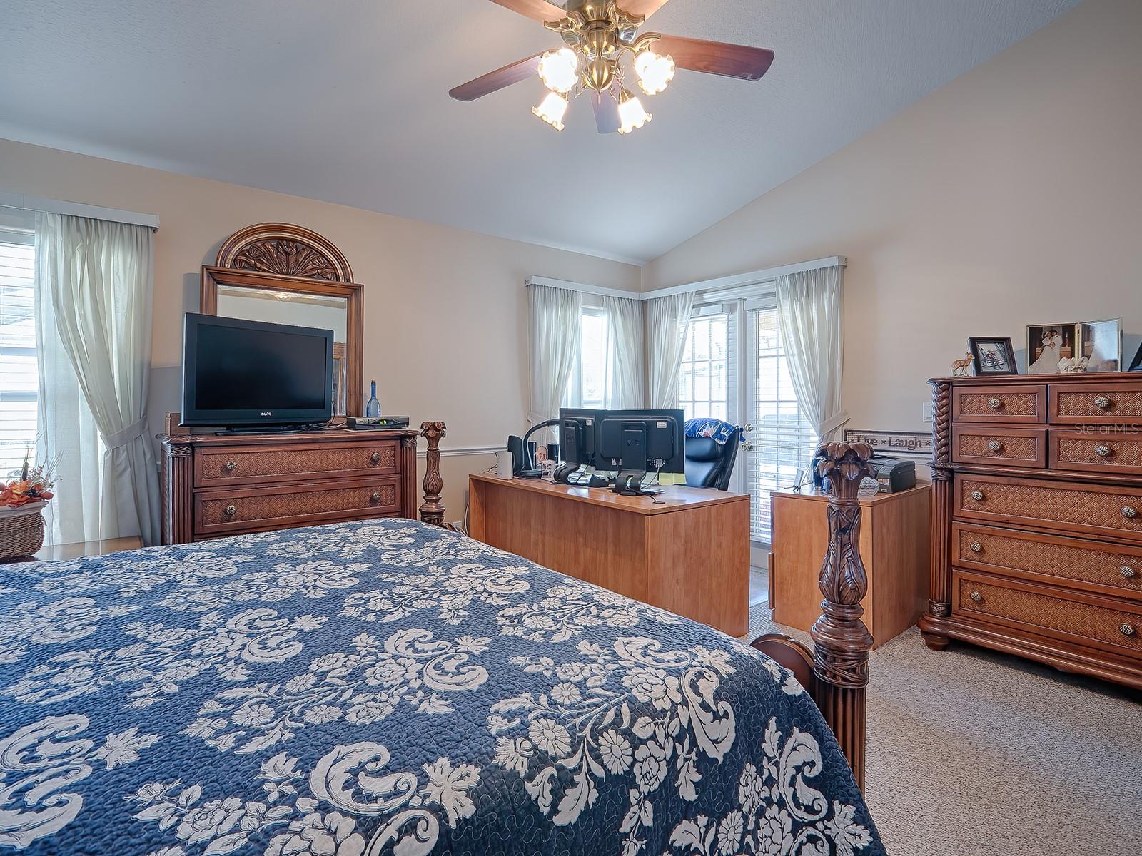 Primary bedroom with french doors leading out to lanai and pool area.