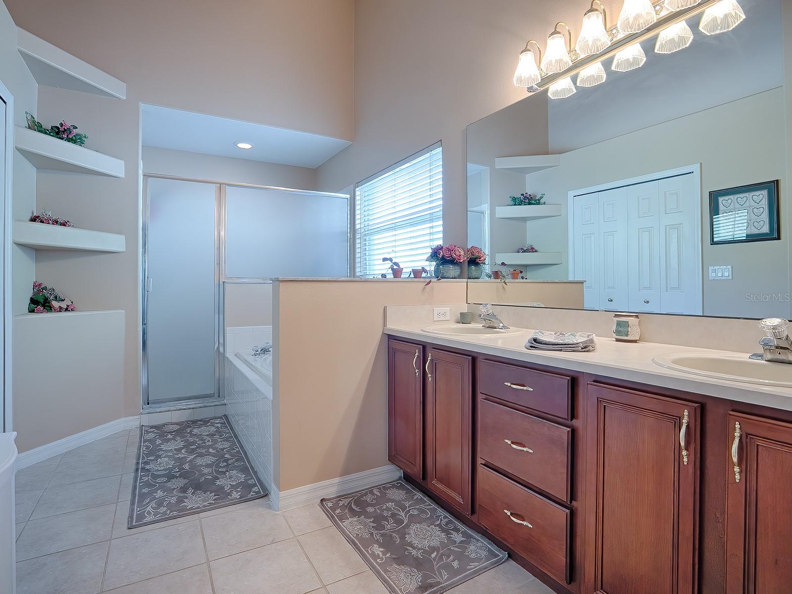 extensive primary bathroom with dual sinks, jetted bathtub, and walk-in shower.