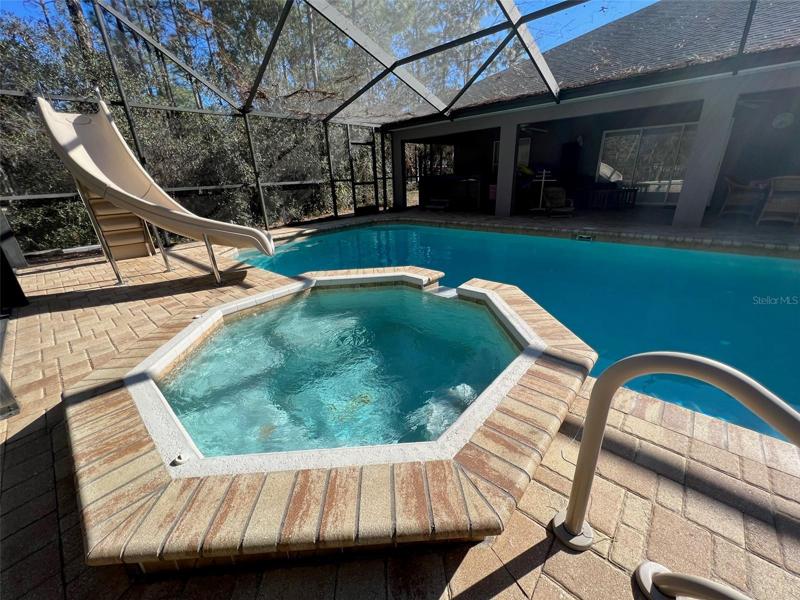 Heated whirlpool that spills over into the pool
