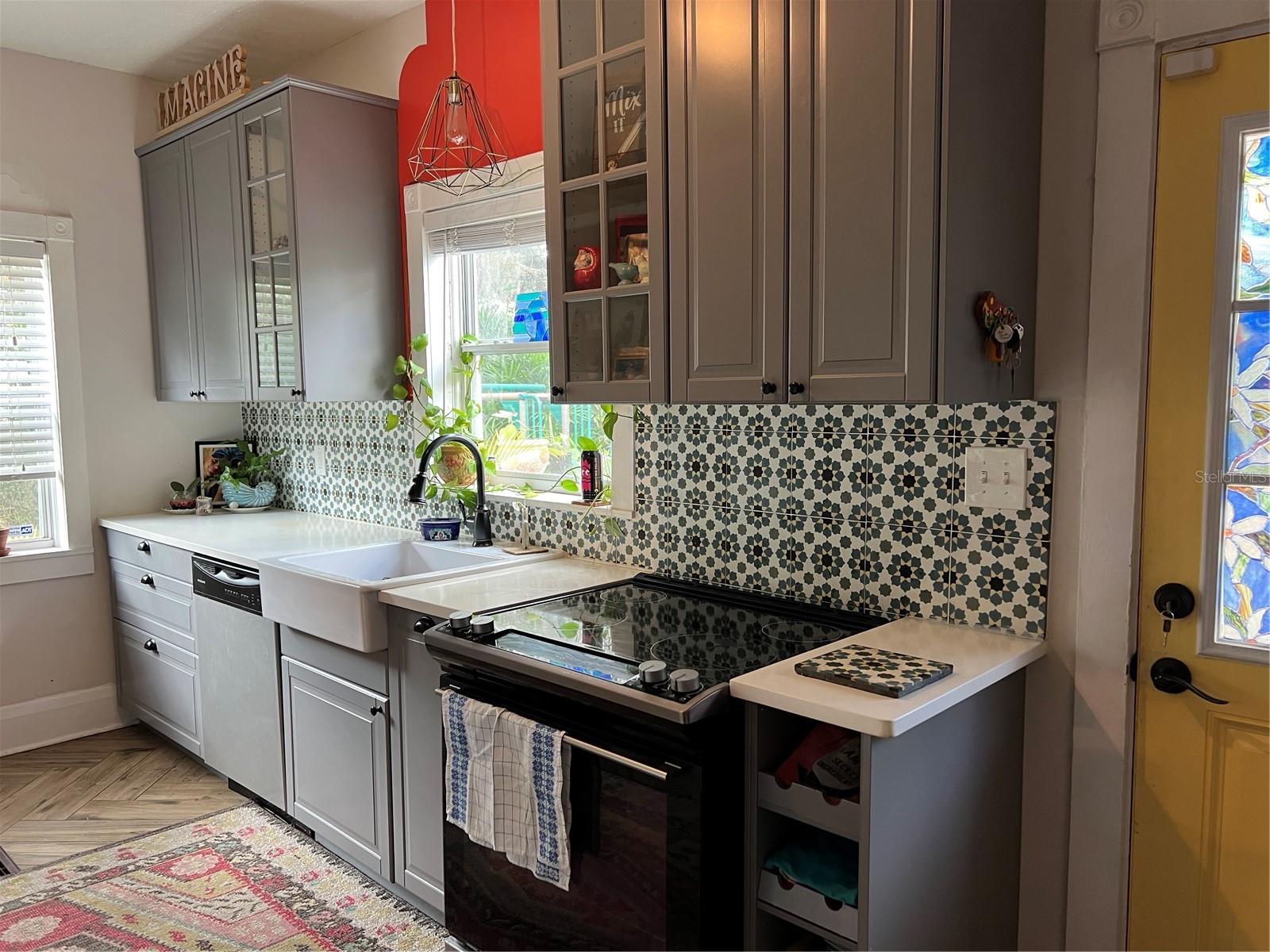 Updated kitchen with plenty of sunshine, storage, built-in shelving and a bar for your favorite beverages.