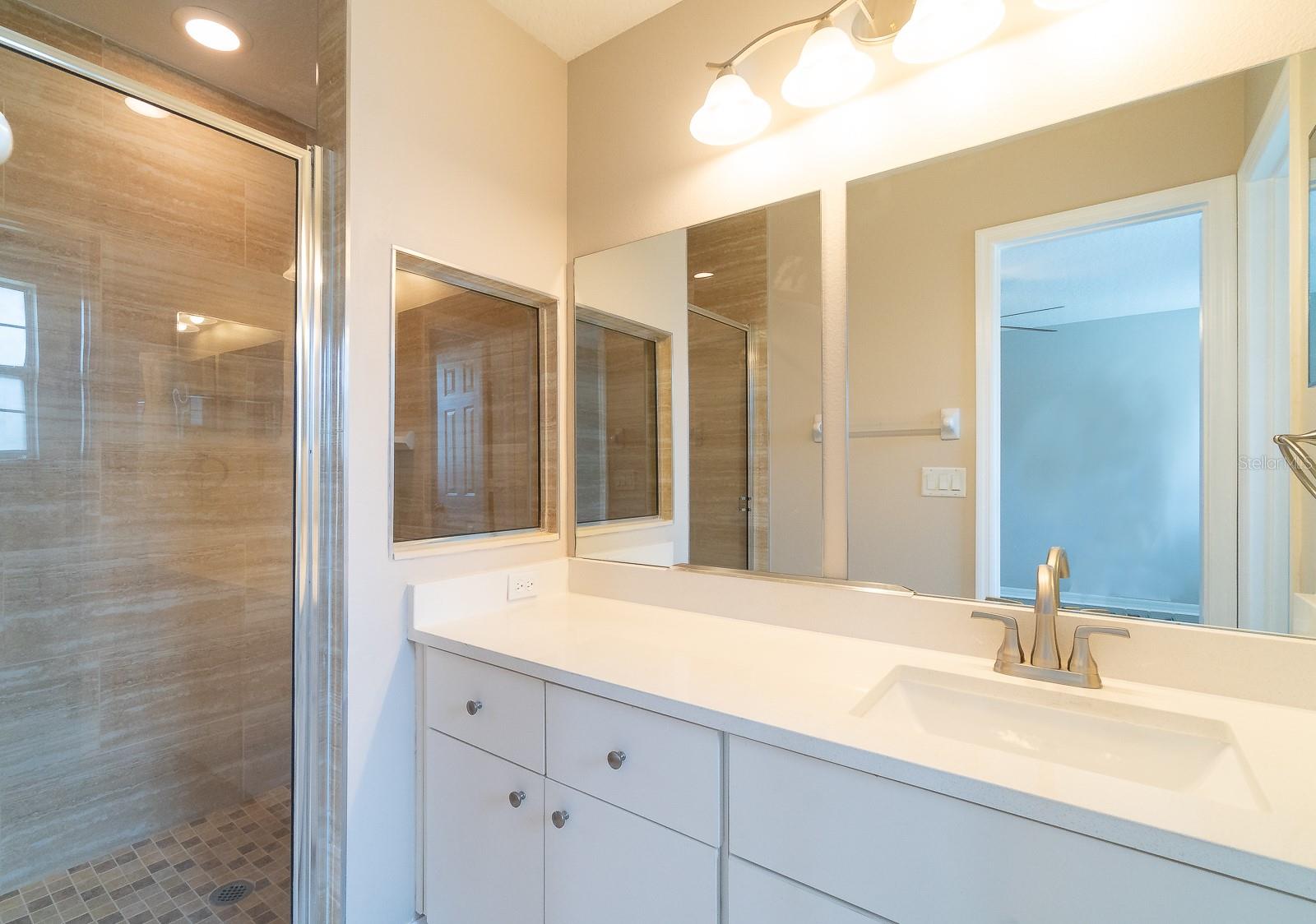 The remodeled en-suite bathroom features quartz countertops, adding a touch of luxury to your daily routine.