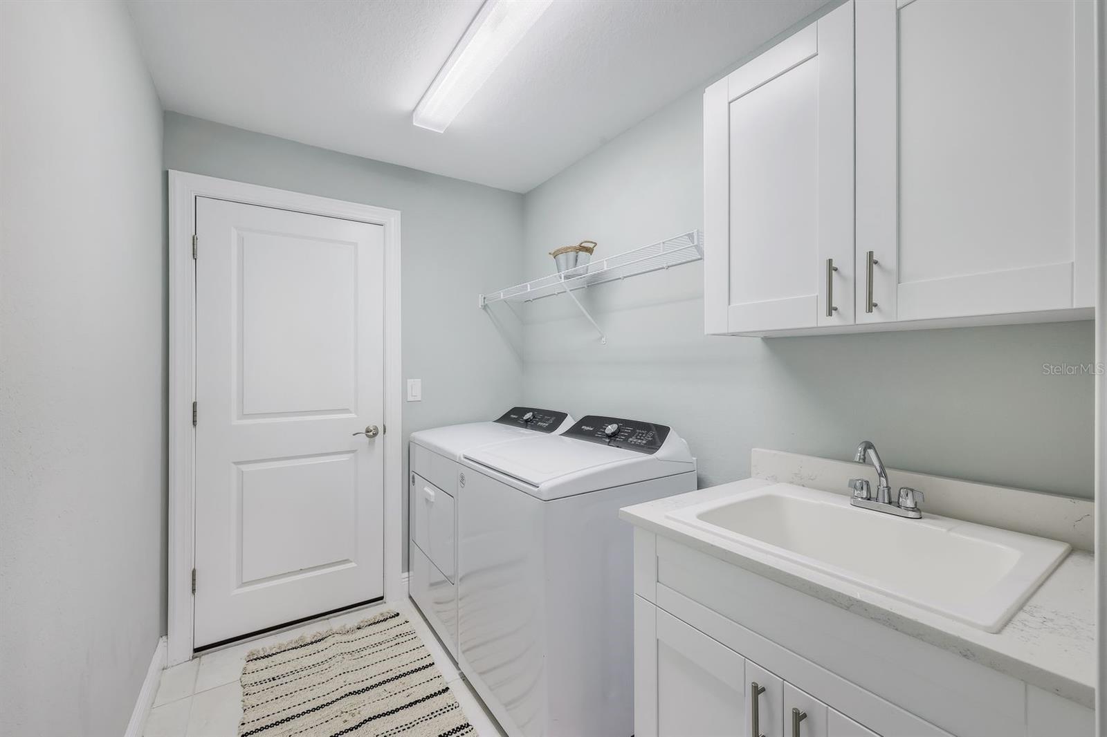 Inside laundry room with sink and cabinets