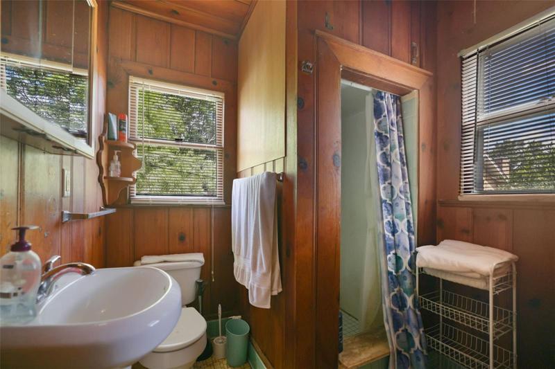 Bathroom upper unit Building 2. Unit has original knotty pine and hardware