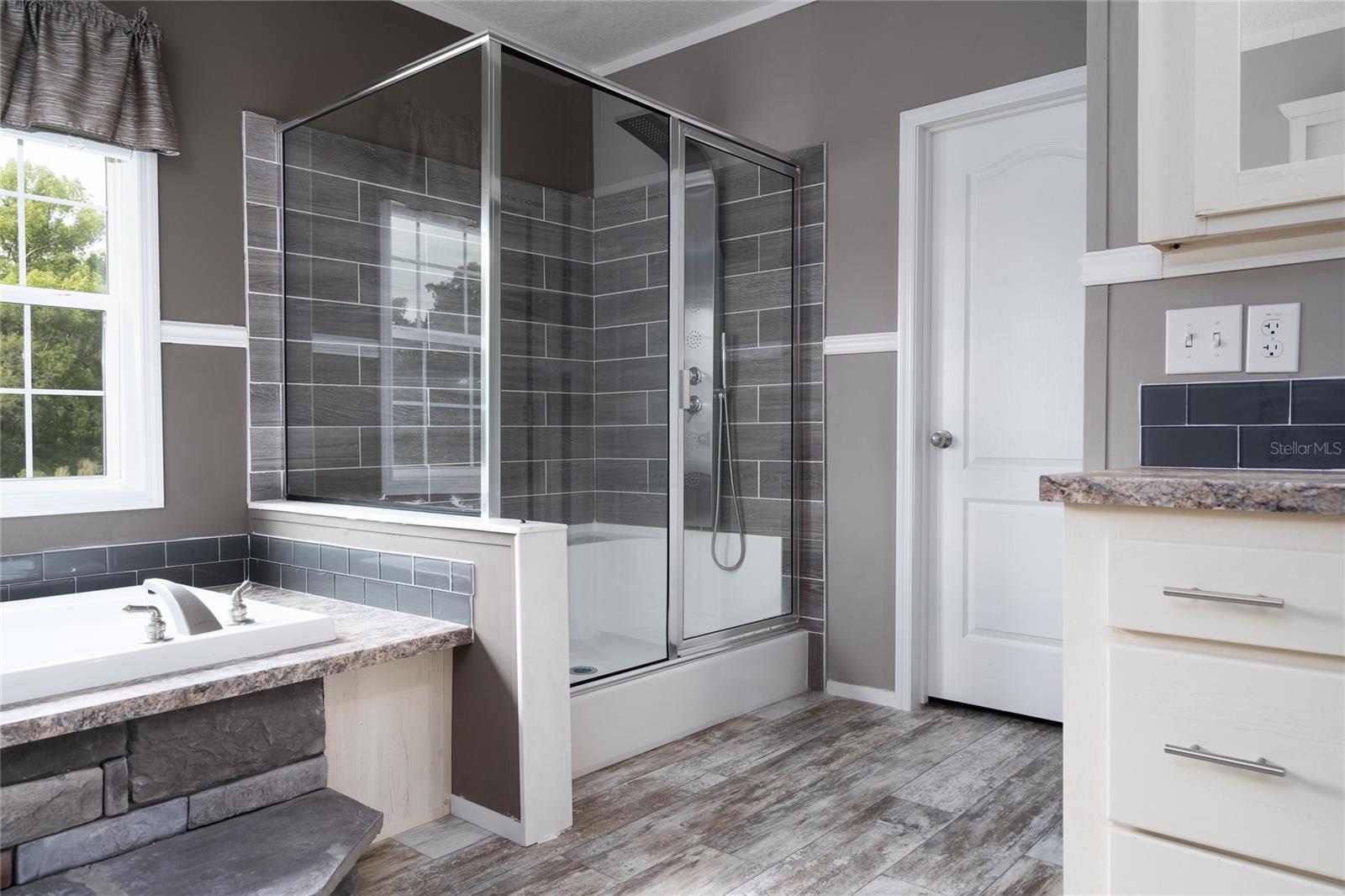 Owner's Suite walk-in shower. Huge walk-in closet afar.