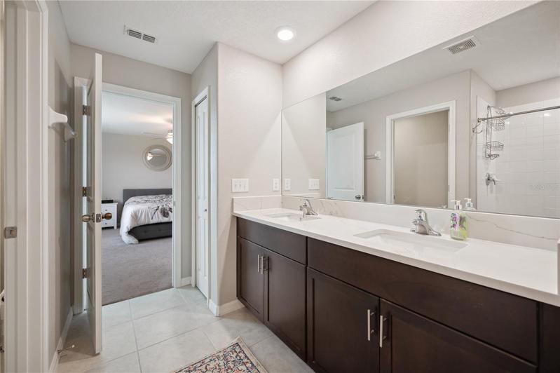 Primary bathroom with quartz countertop dual sink vanity
