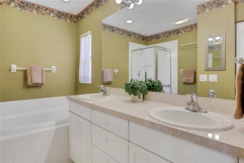 Primary ensuite bathroom with dual sinks and tub