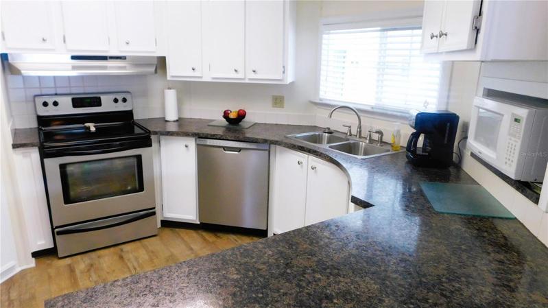 Open kitchen with updates including flooring, counter tops, appliances, and fixtures.
