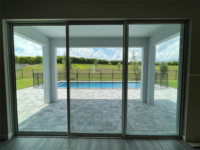 Triple sliding glass doors with view of the expansive backyard